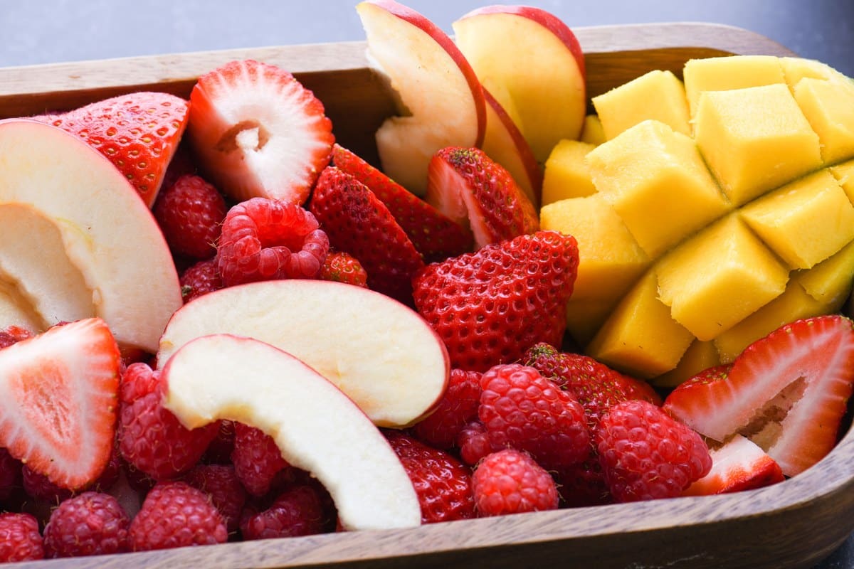 Verschiedene Obststücke als Frischkost für Wellensittiche